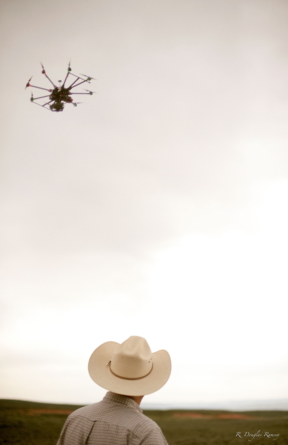 A farmer looking at a drone.