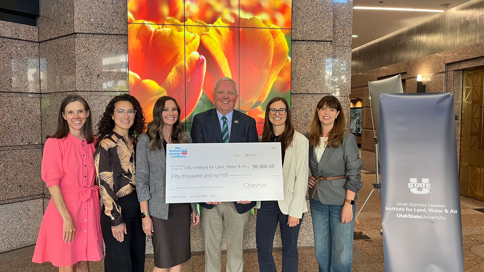 People holding a giant check for 50,000 dollars.