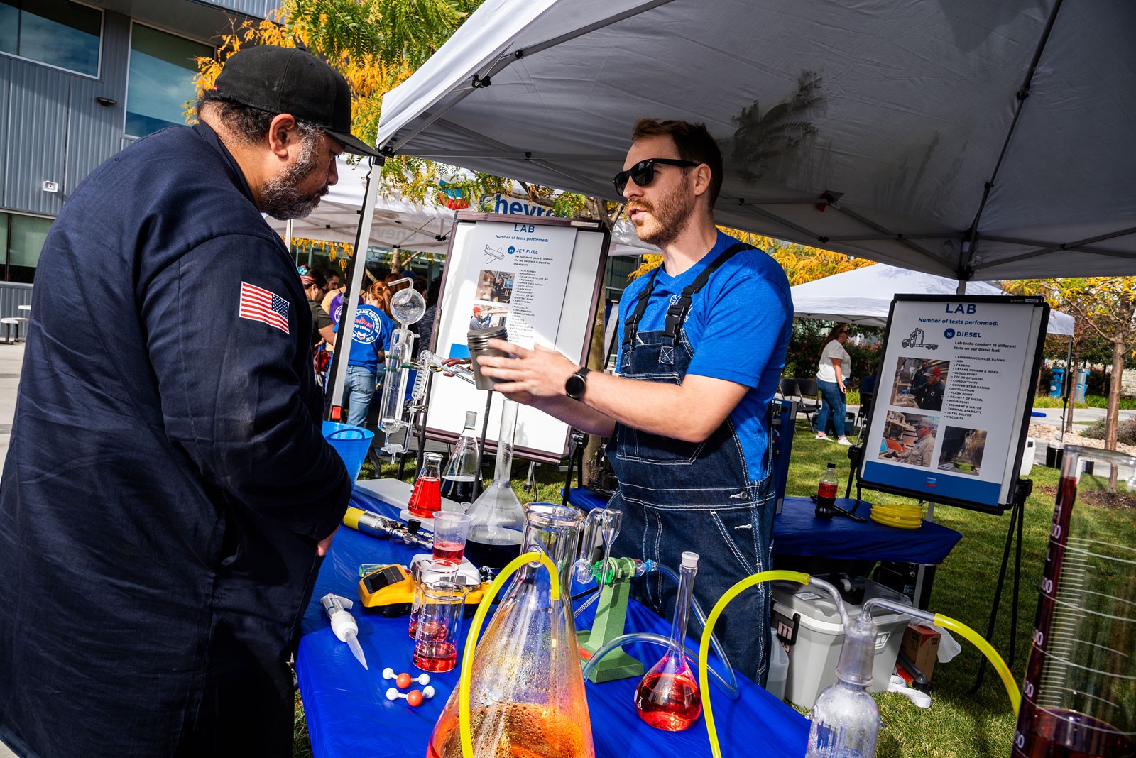 People speaking at a booth during an event.