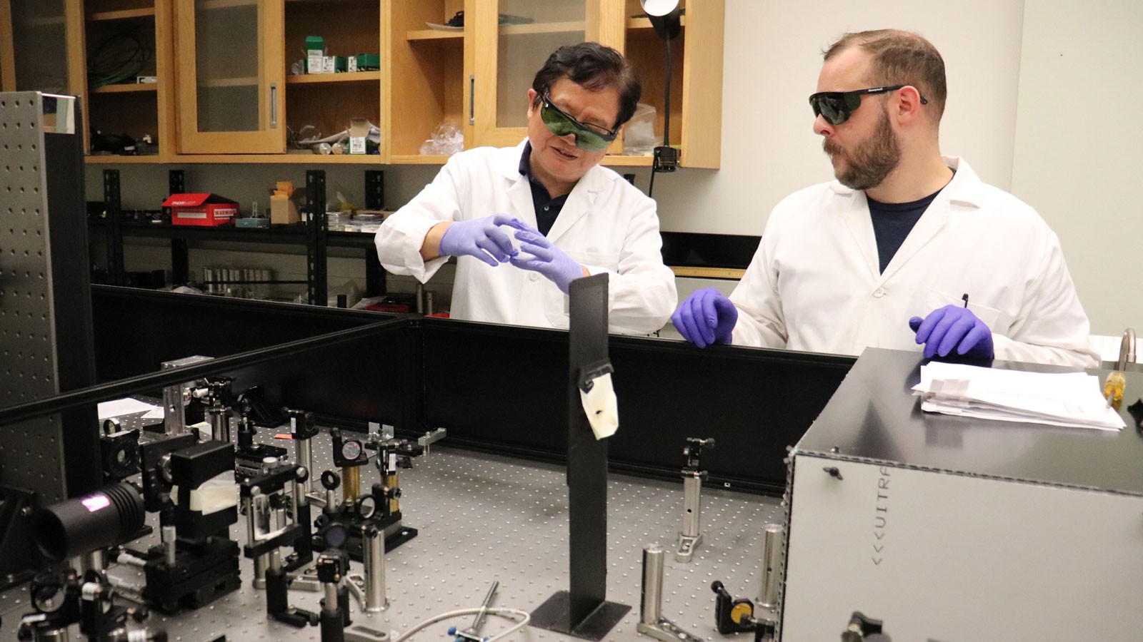 Yi Rao and Jesse Brown wearing protective equipment in a lab.