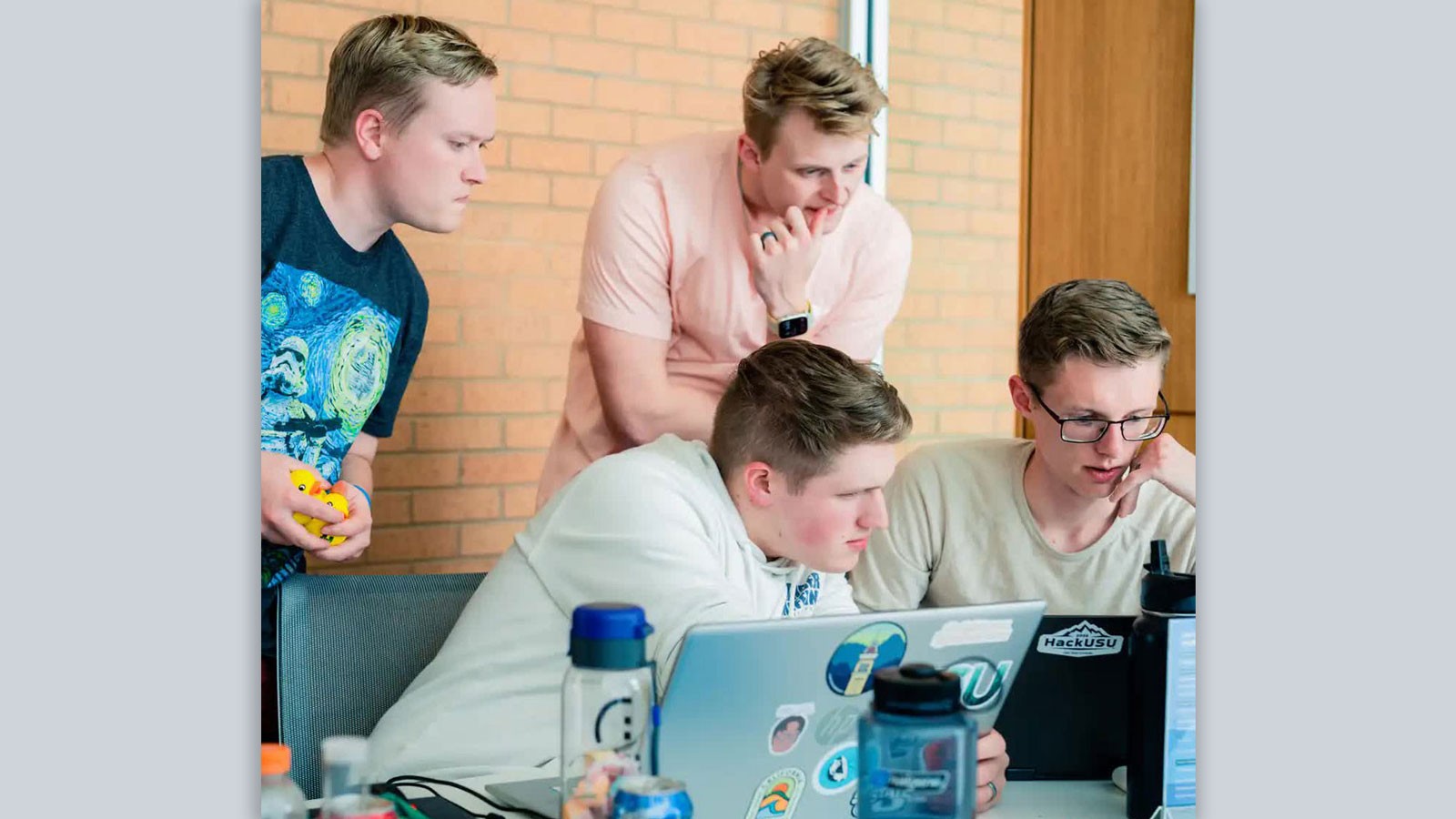 Students coding with laptop computers.