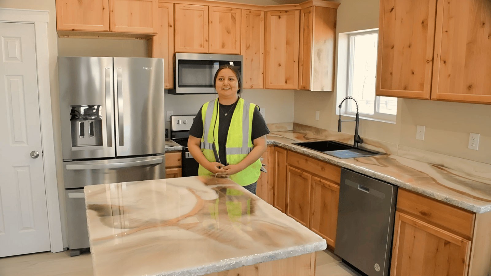 Faith Toglena standing in a newly constructed kitchen.