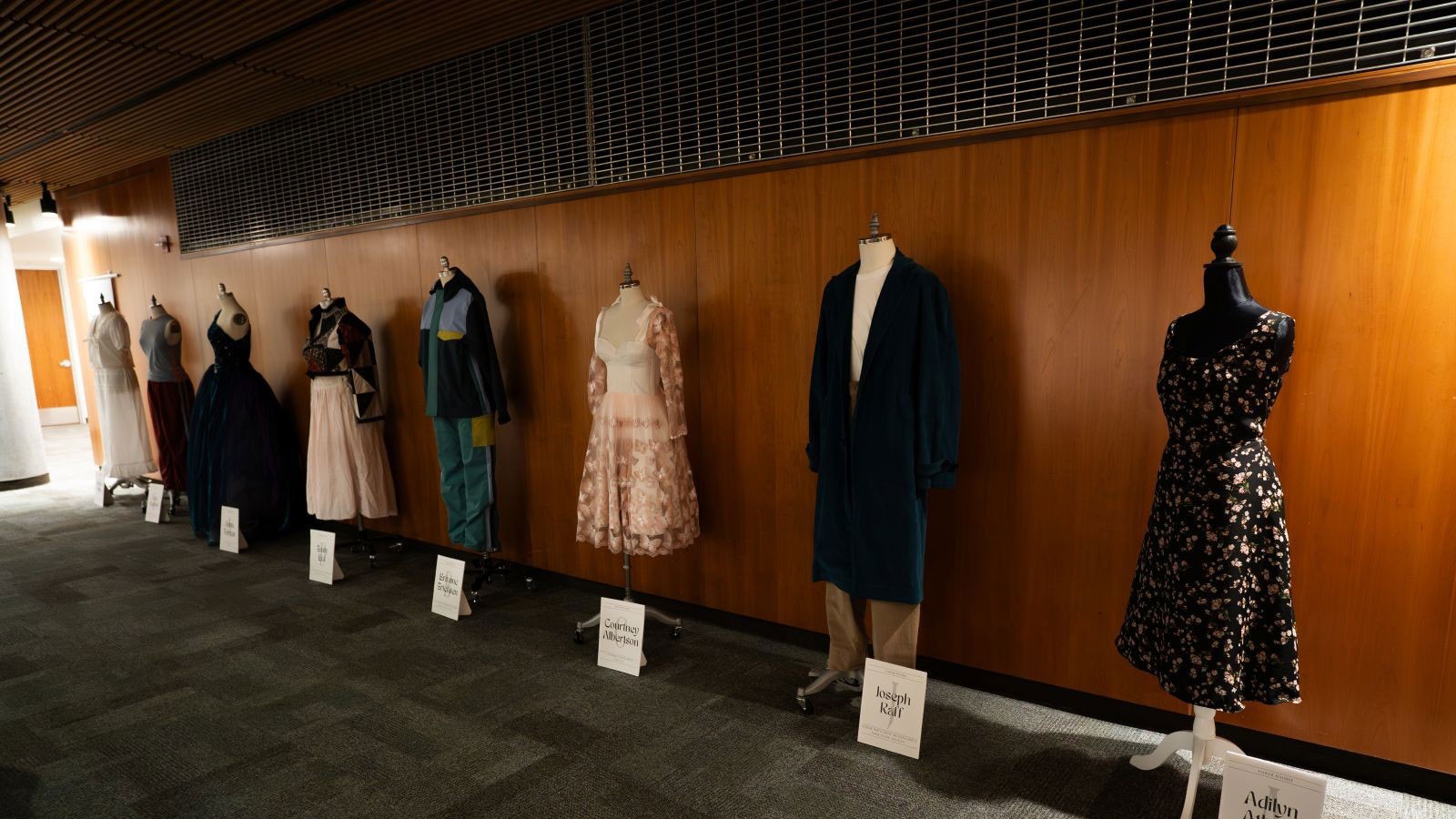 An exhibit of mannequins wearing clothing styles from different decades.