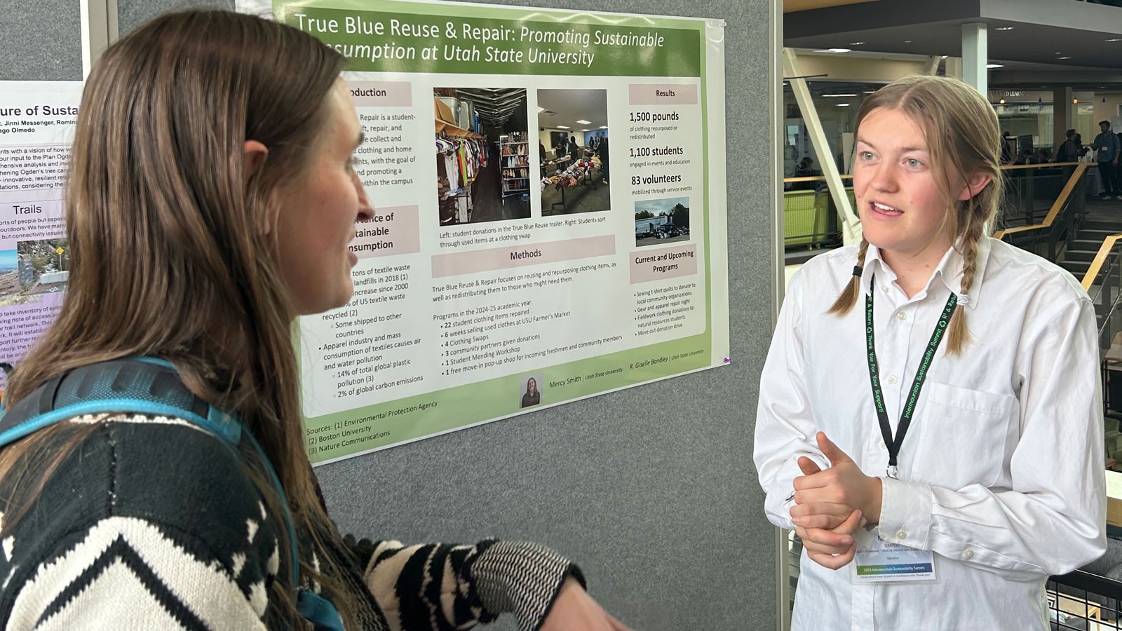 People speaking in front of a research poster.