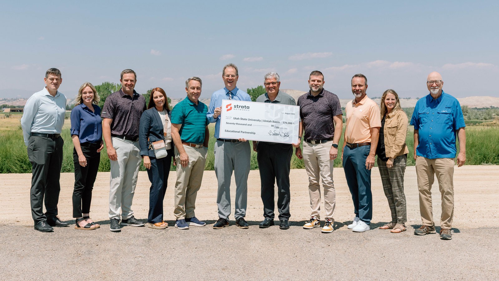 A group of people holding a giant check for 70,000 dollars.