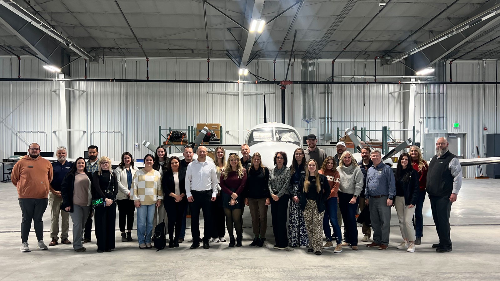 A group of people in an airport hangar.