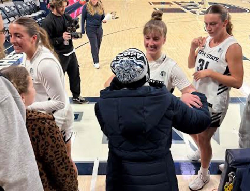 Fans and basketball players talking with each other courtside.