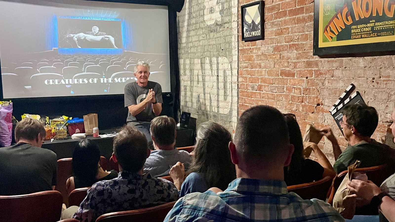 David Wall speaking to an audience in a cinema.
