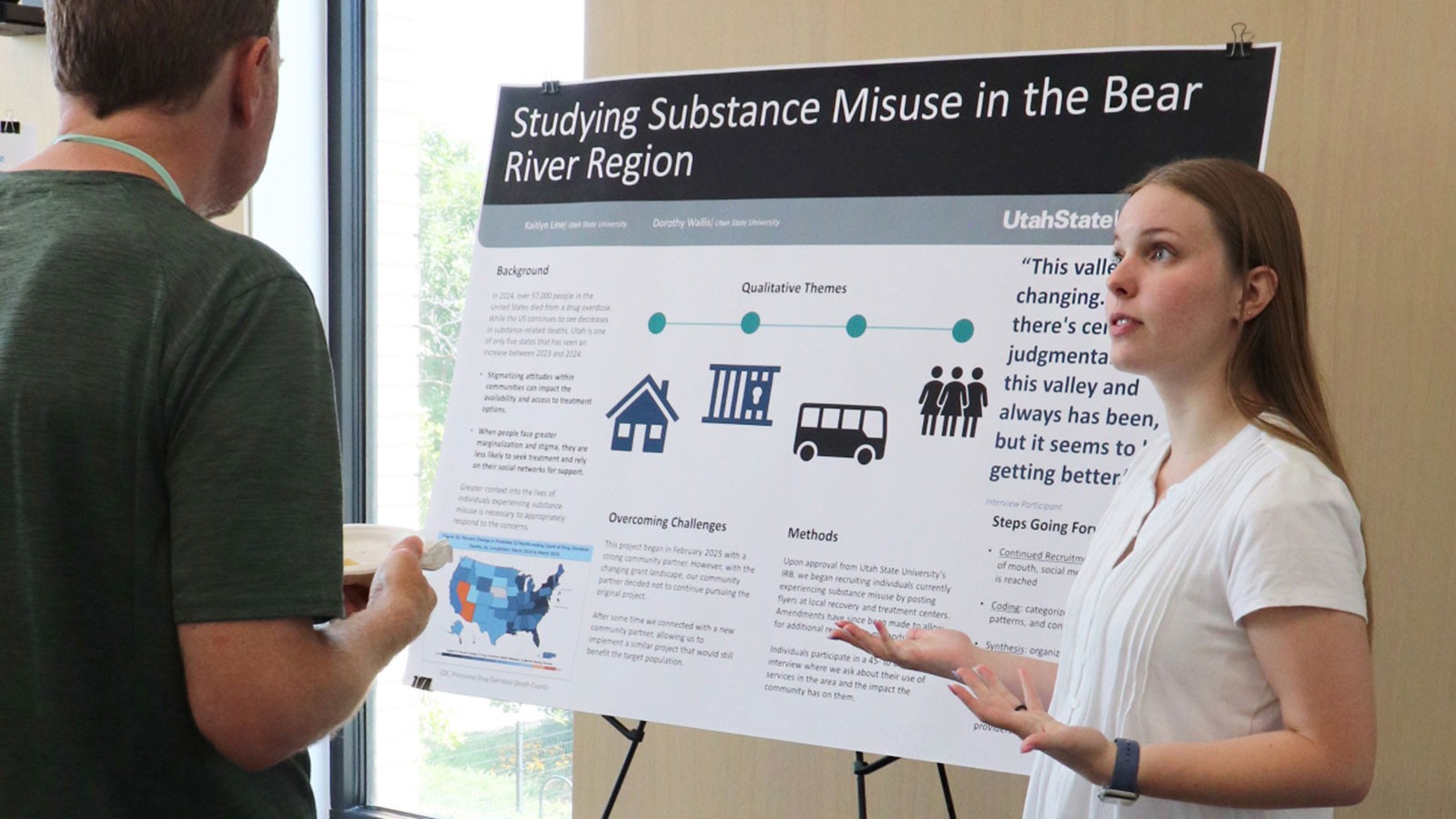 Kaitlyn Line demonstrating a research poster.