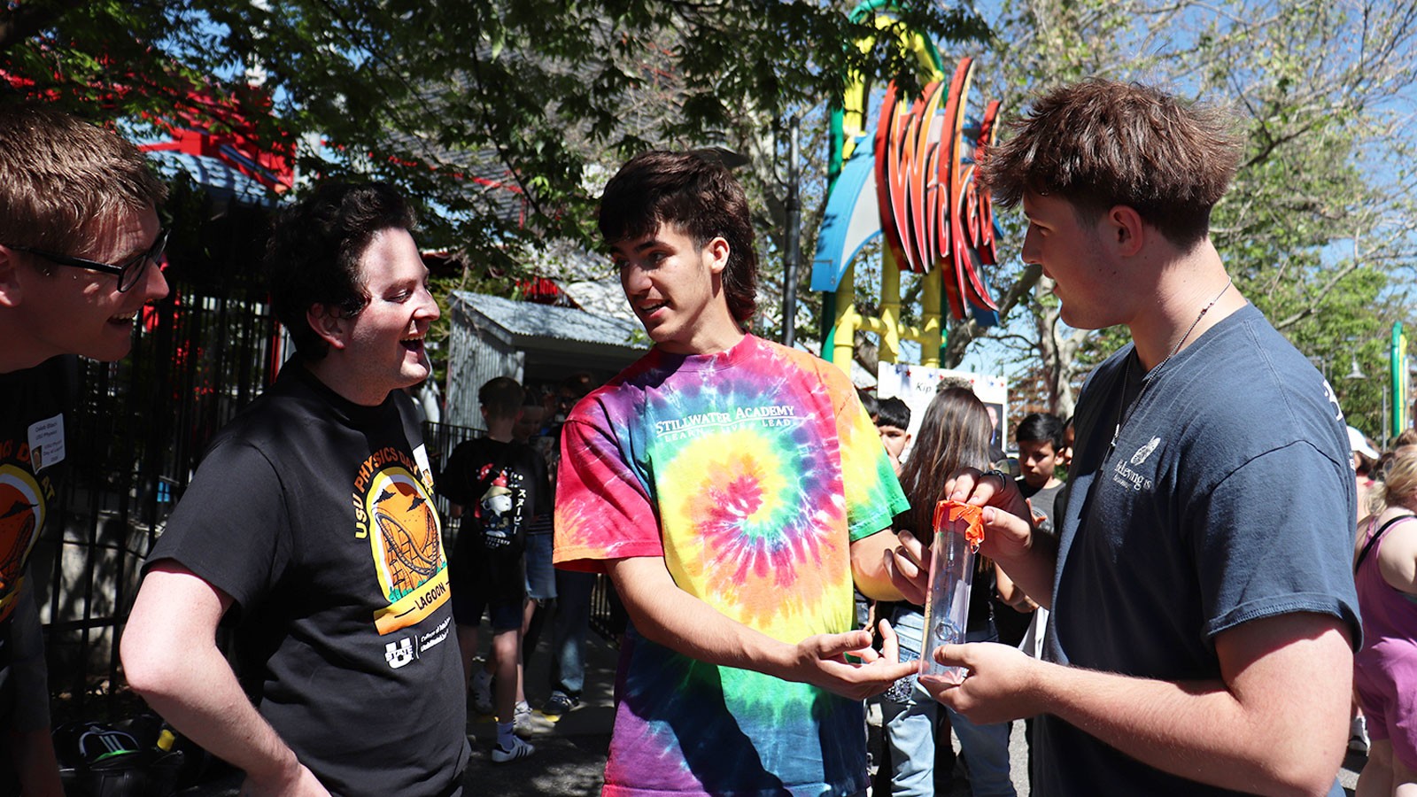 Four young people at an amusement park.