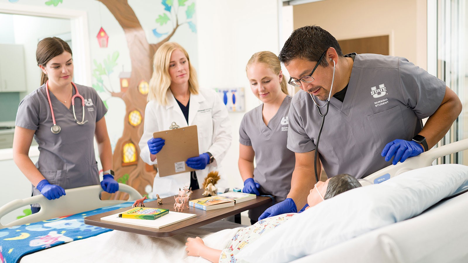 Nursing students working with a mannekin.