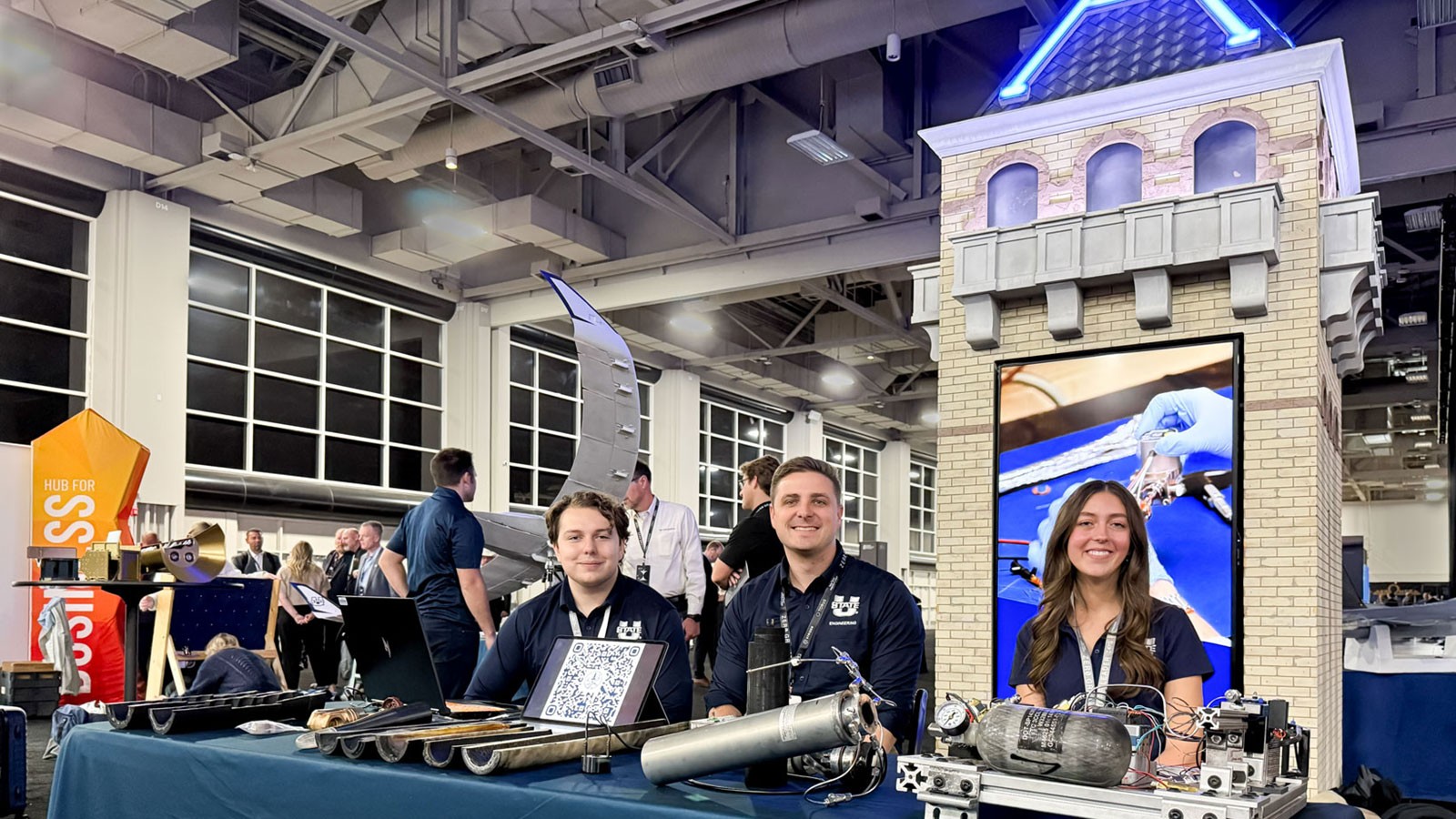 People attending the Zero G Summit in front of a model of Old Main.