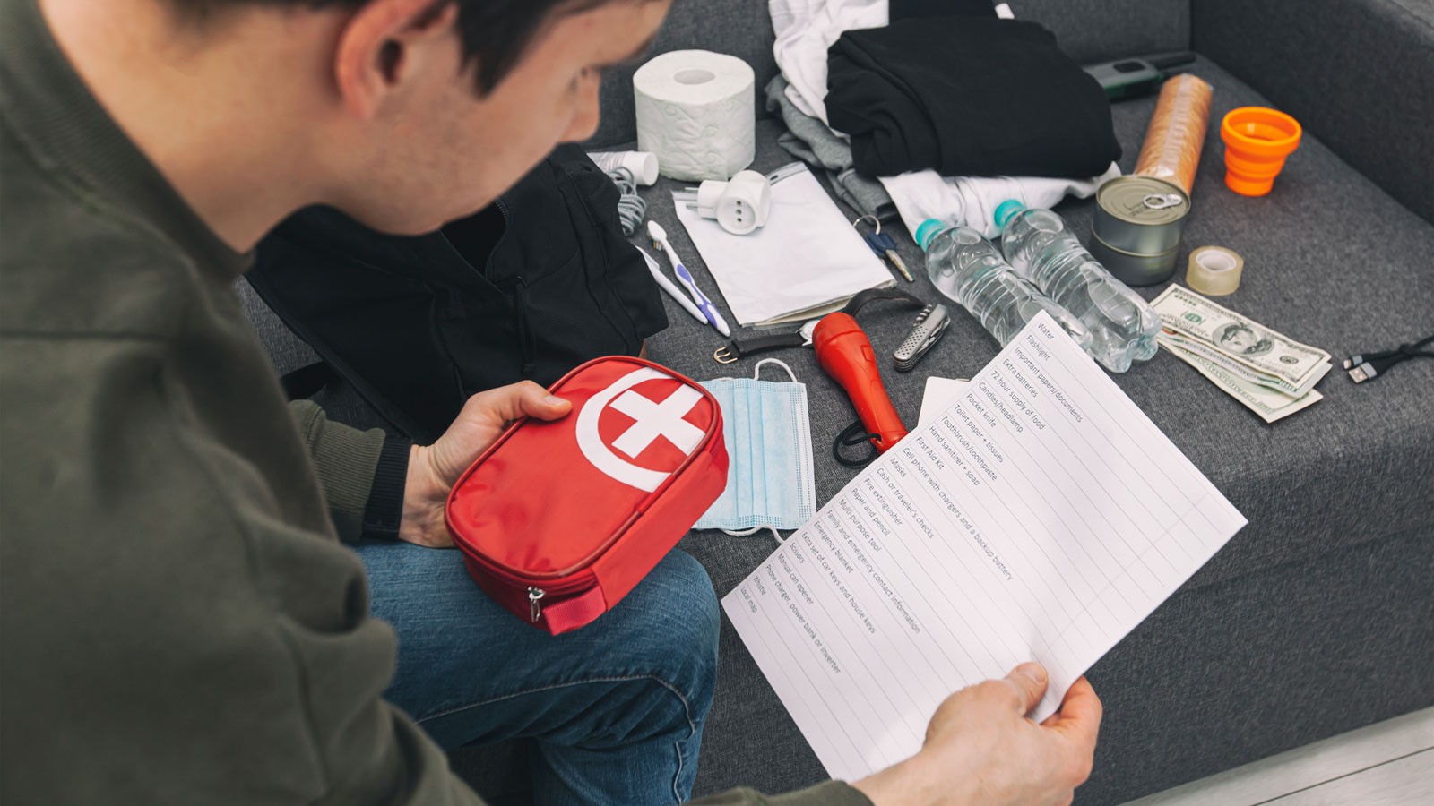 A person examining an emergency kit.