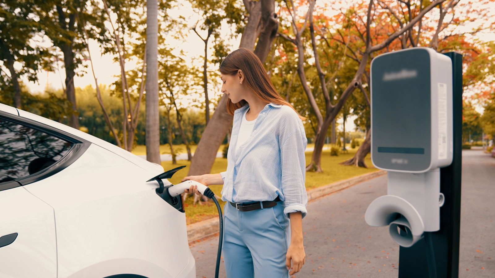 A person plugging in an electric vehicle.