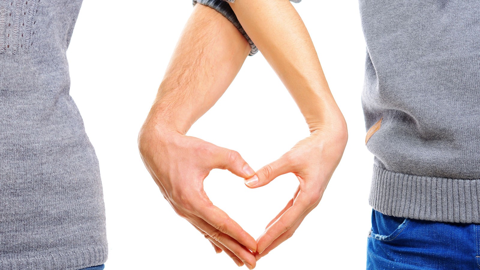 Two people making a heart outline with their hands.