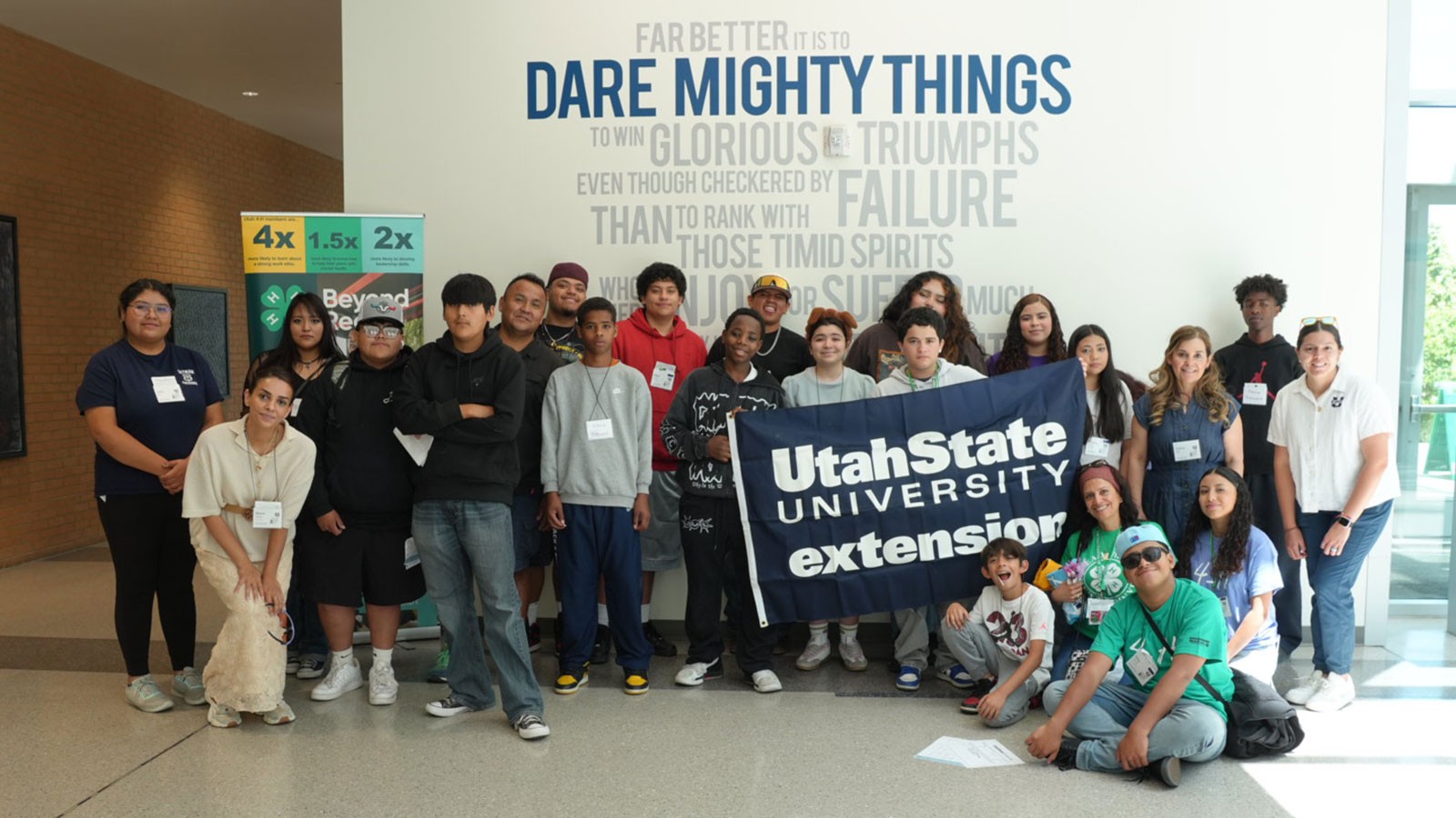 People in a group photo holding a sign that says USU Extension.