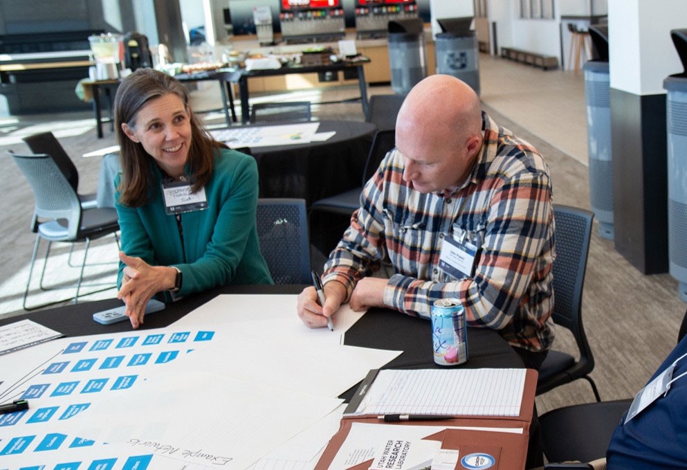 Jake Powell and Stephanie Frohman working at a conference.