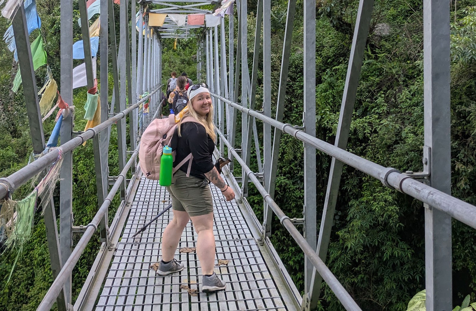 People crossing a foot bridge while hiking in Nepal.