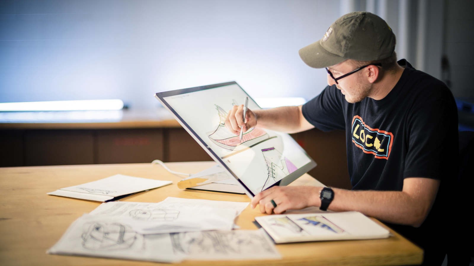 A person drawing a shoe design on a tablet computer.