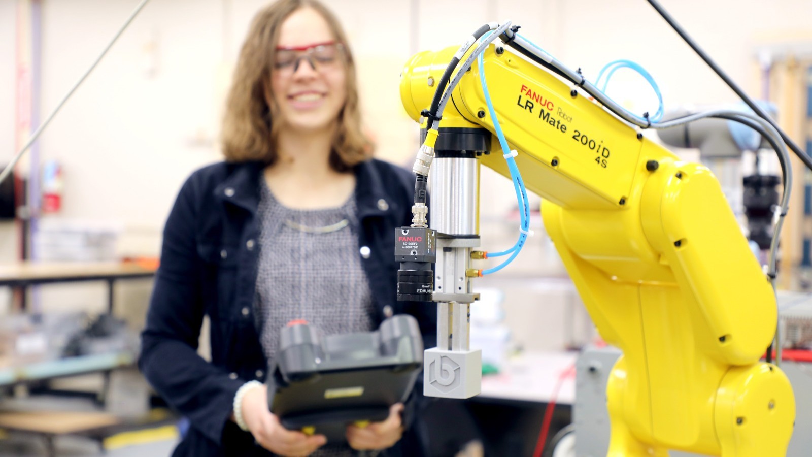 A female student uses a robotic arm machine.
