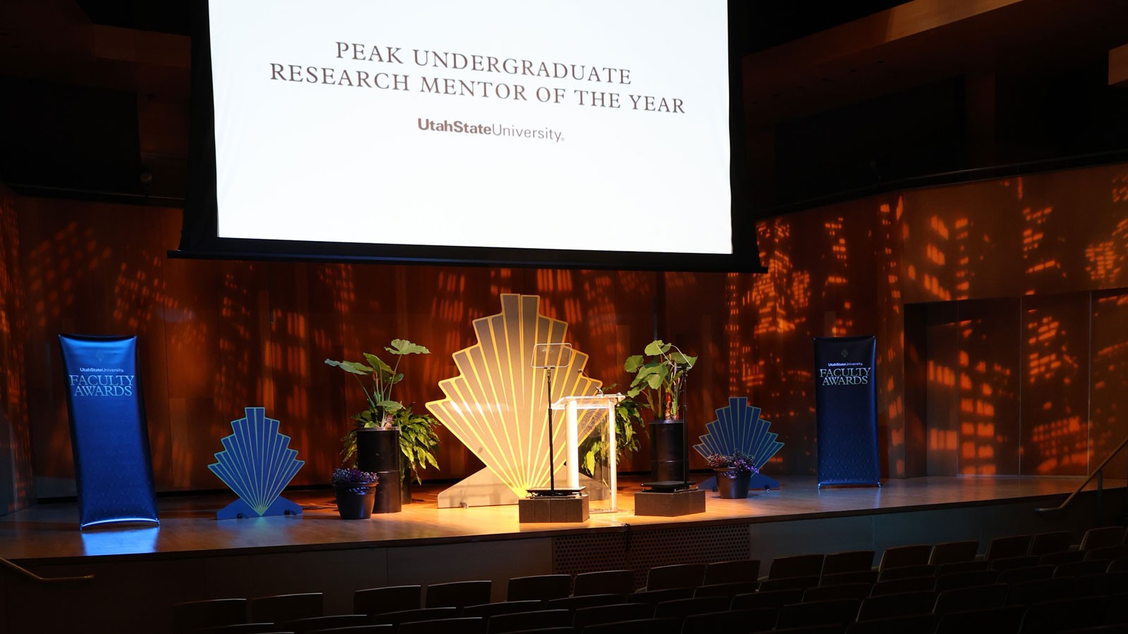 A performance hall. Text on screen reads: Peak Undergraduate Research Mentor of the Year.