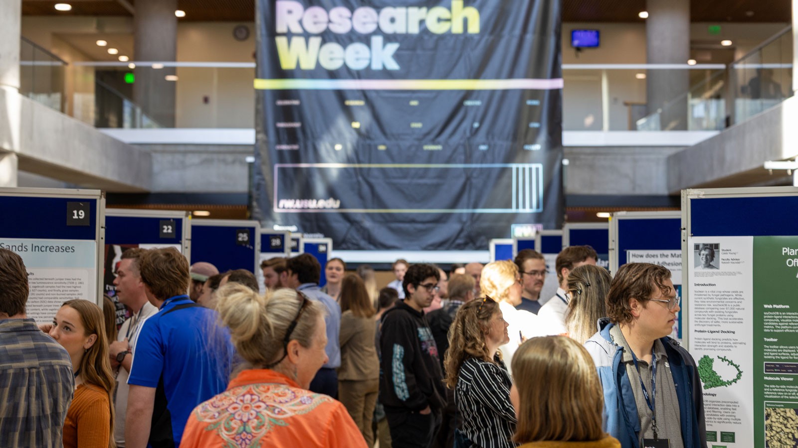 People examining research posters at an event.