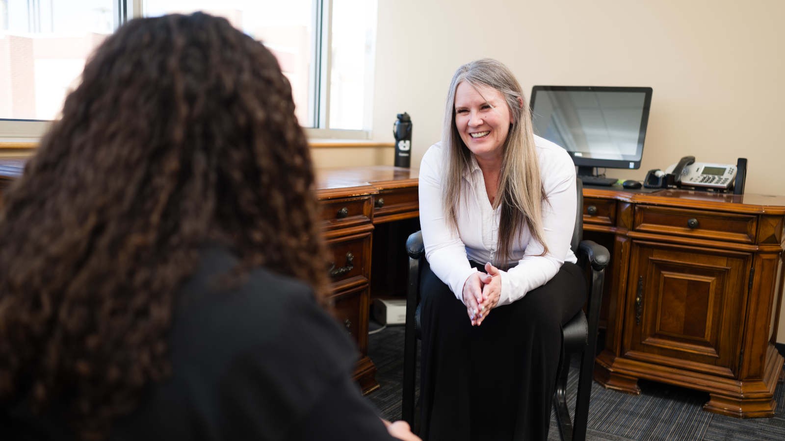 A student talking with a counselor in an office.