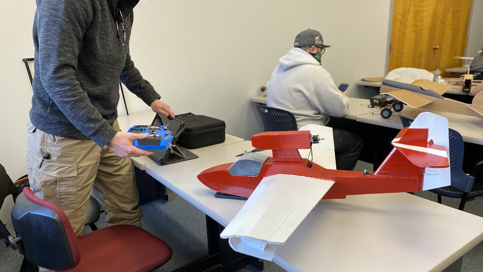 USU students working on a model airplane with a built-in camera.