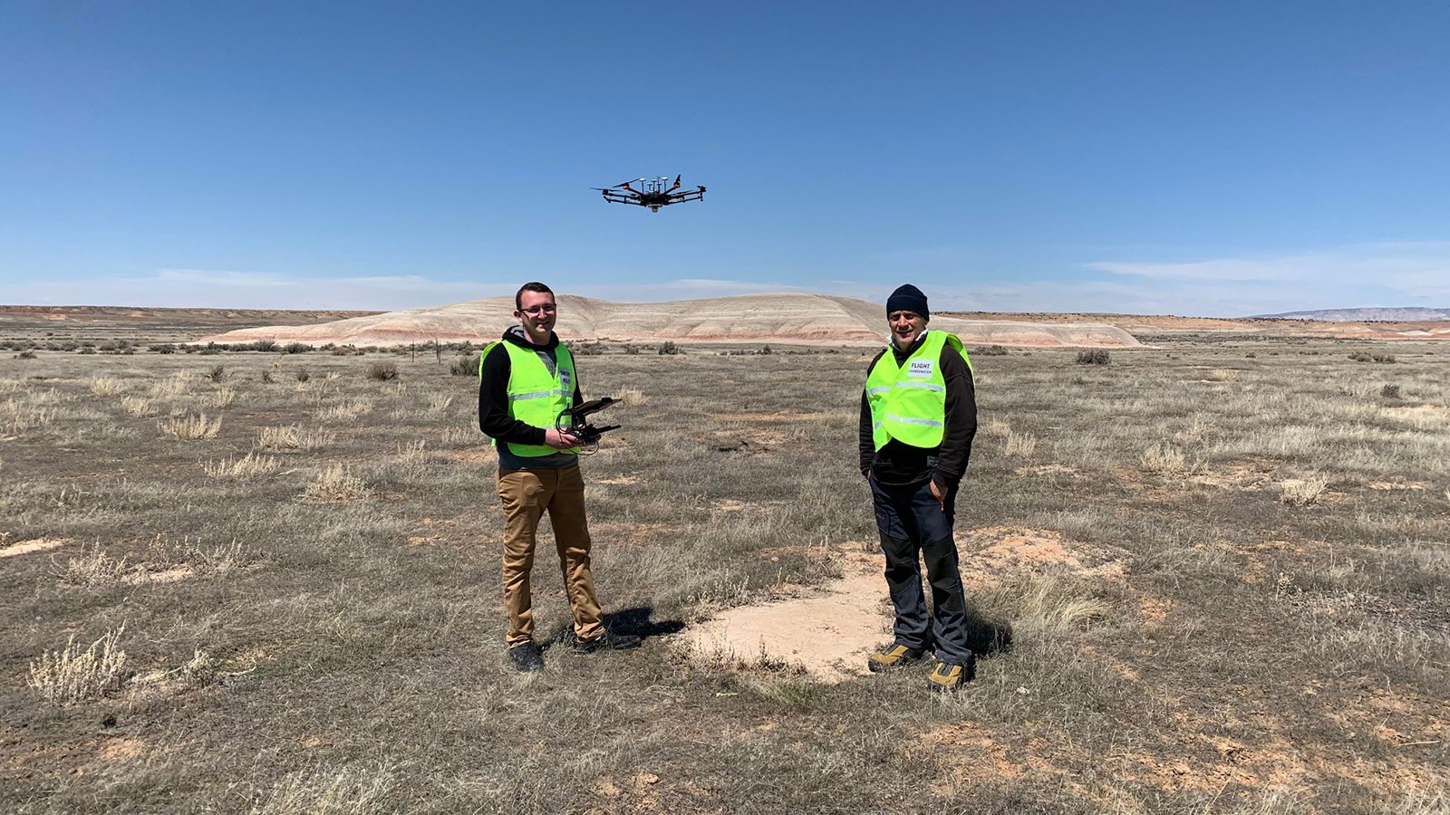 Members of the AggieAir team fly a drone in a field near Vernal, Utah.