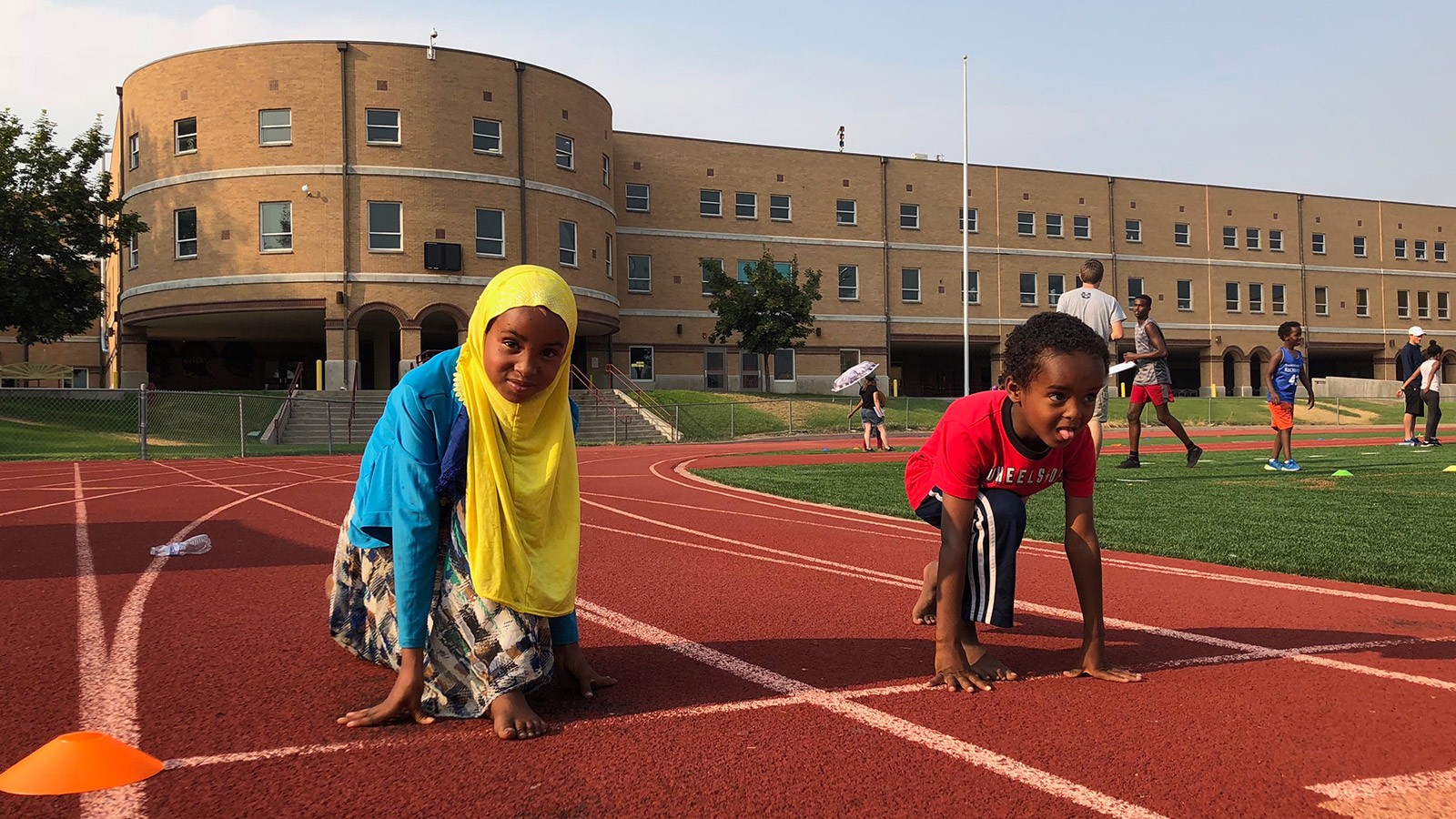 two children running on a track.