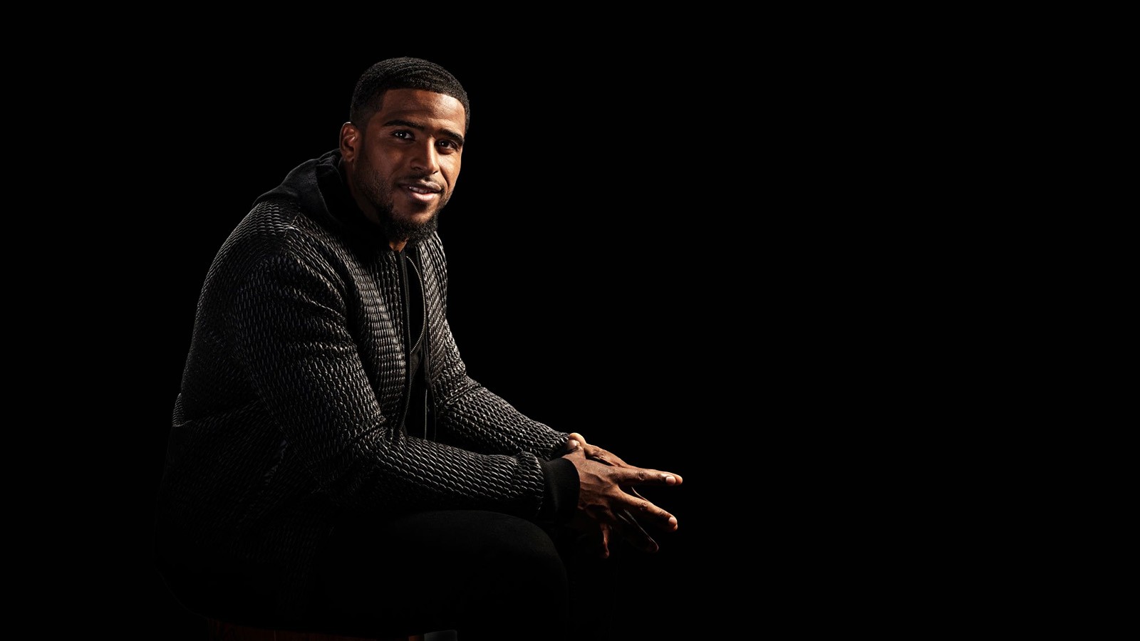 USU Football Player Bobby Wagner poses in black shirt with black background