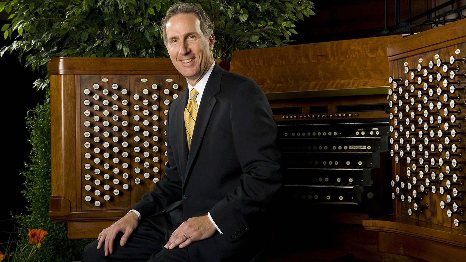 Richard Elliott poses in front of a pipe organ console.