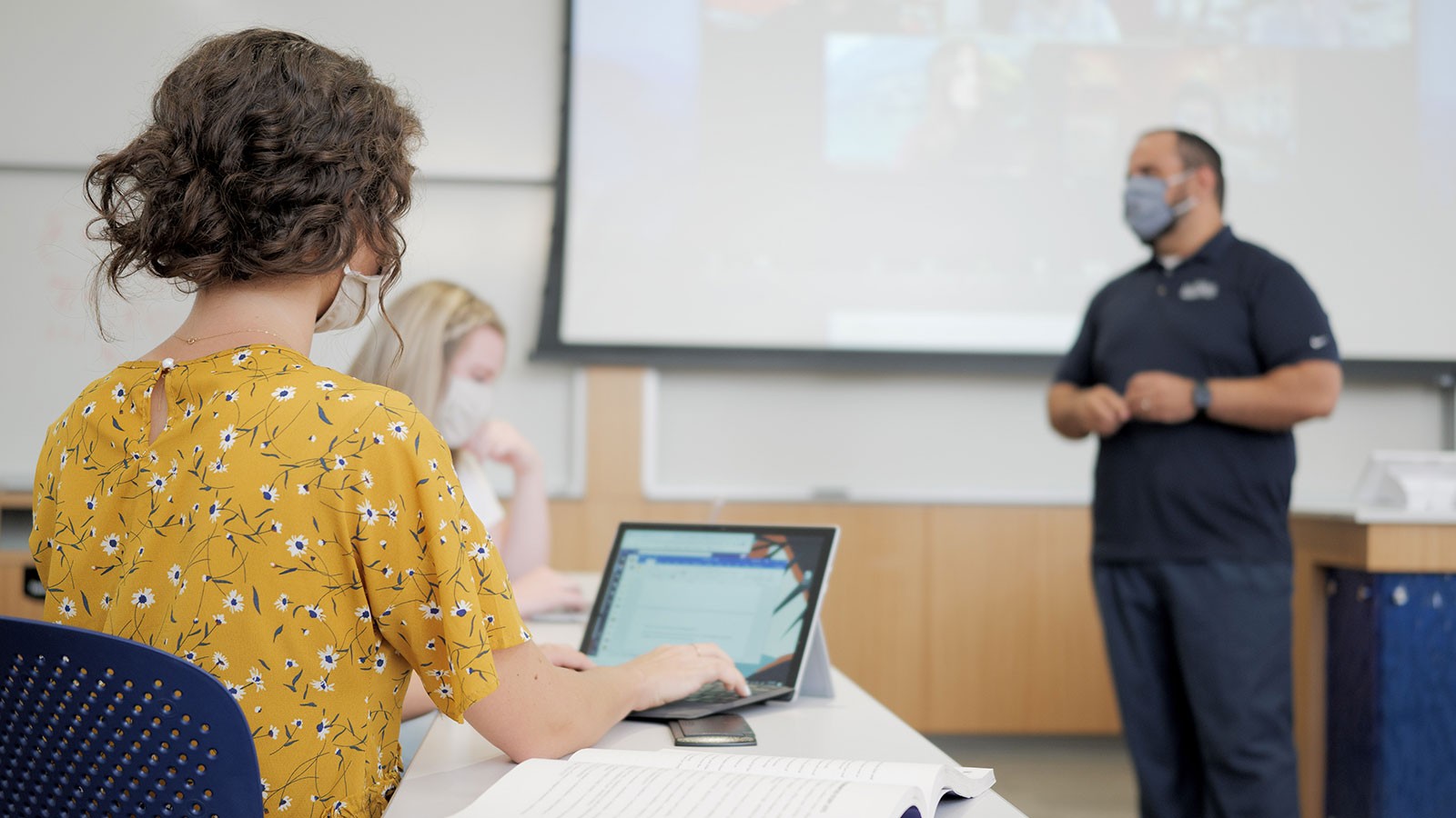 student using a laptop in a classroom.