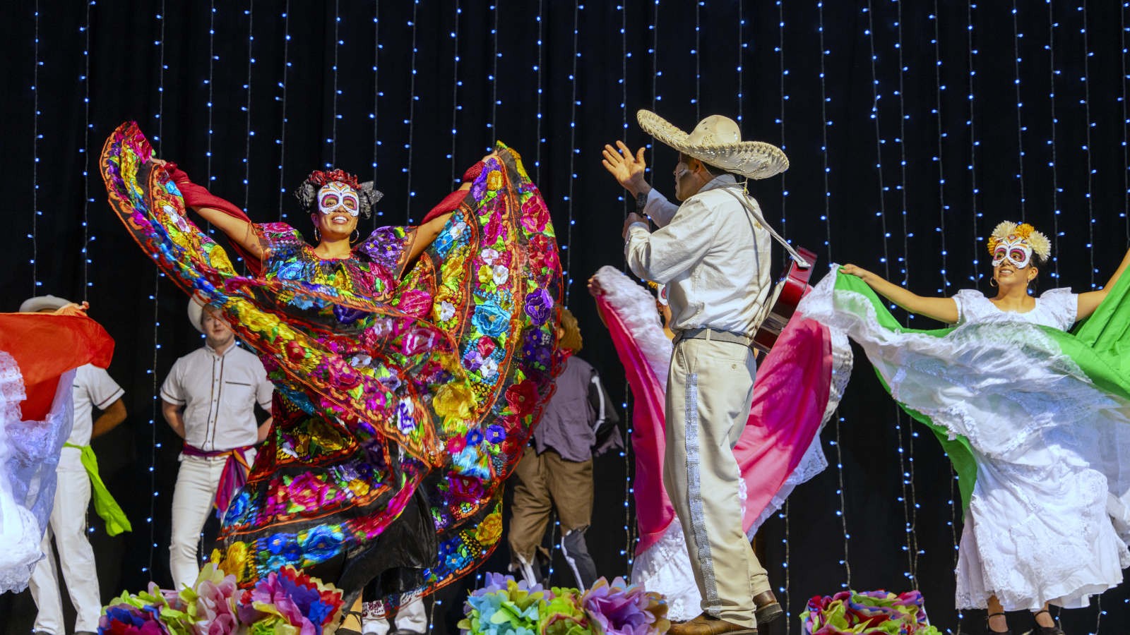 Latino singers and dancers on stage.