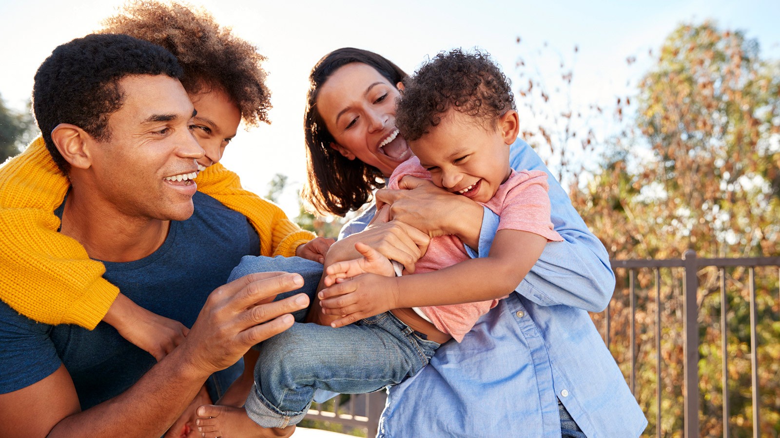 Family outside laughing and hugging.