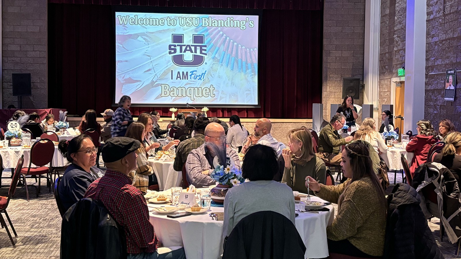 A group of people sit at a table during a banquet talking.