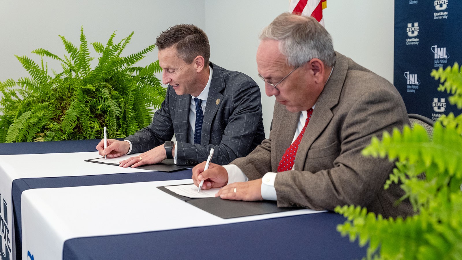 Brad Mortensen and Todd Combs signing documents.