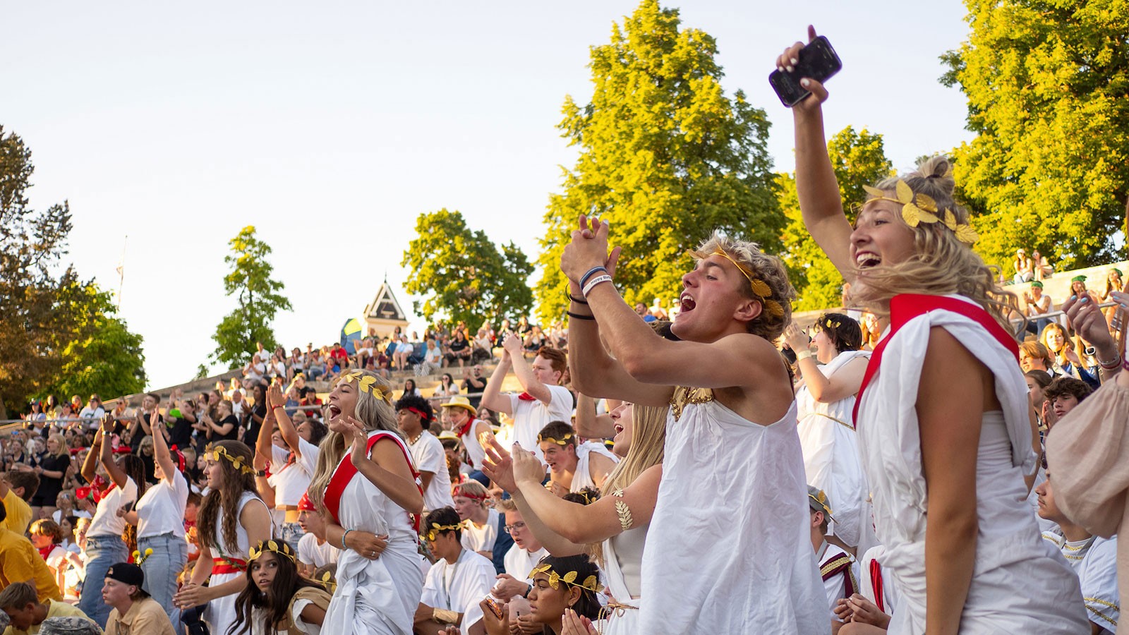 People cheering and wearing Ancient Greece-themed costumes.