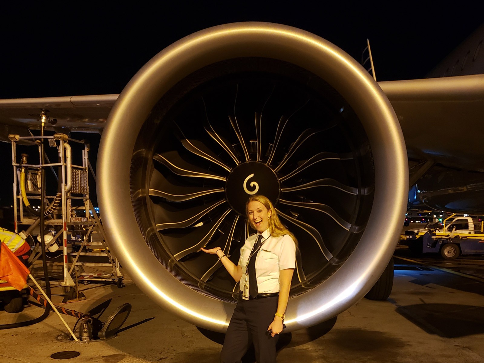 Jessica Hines stands next to an airplane.