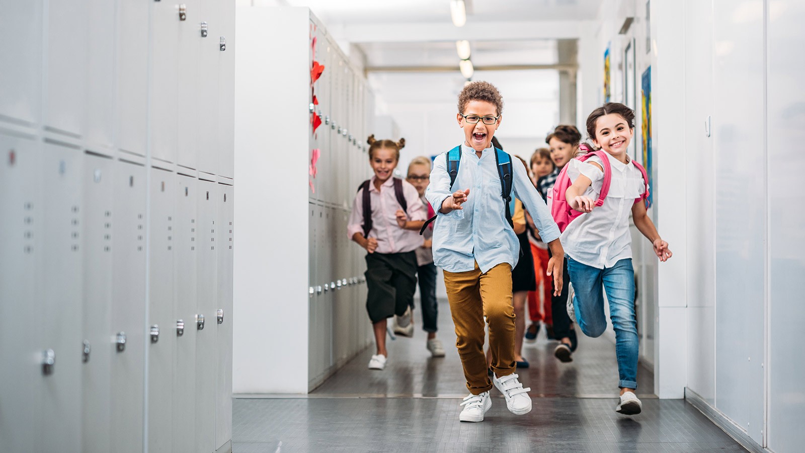 Children running down a school hallway.