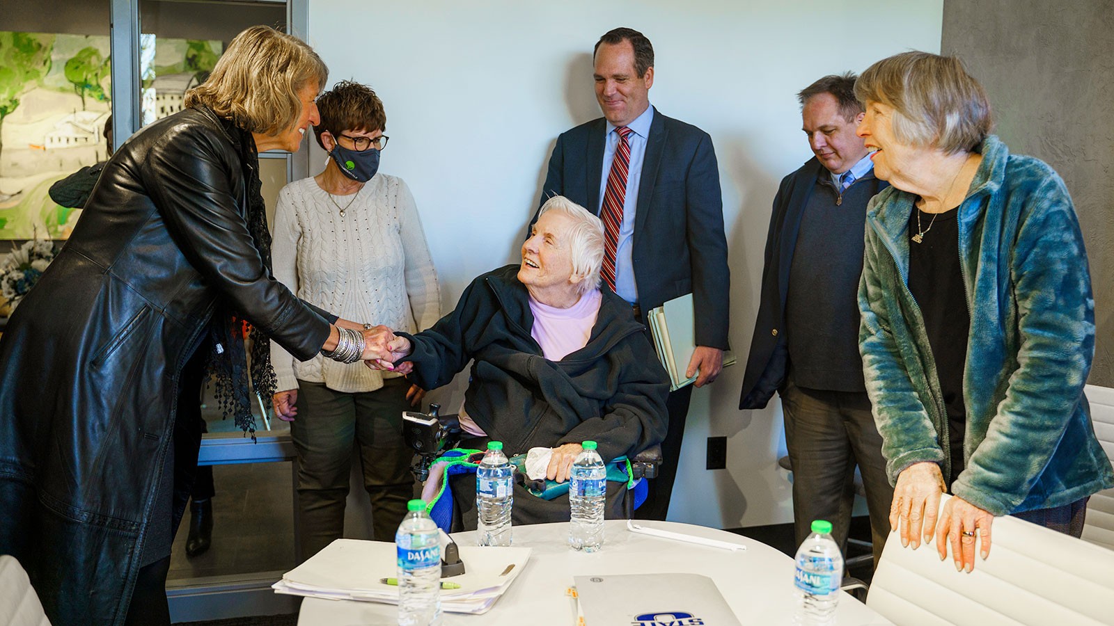 USU President Noelle Cockett shakes hands with Mary Bastian as others look on.