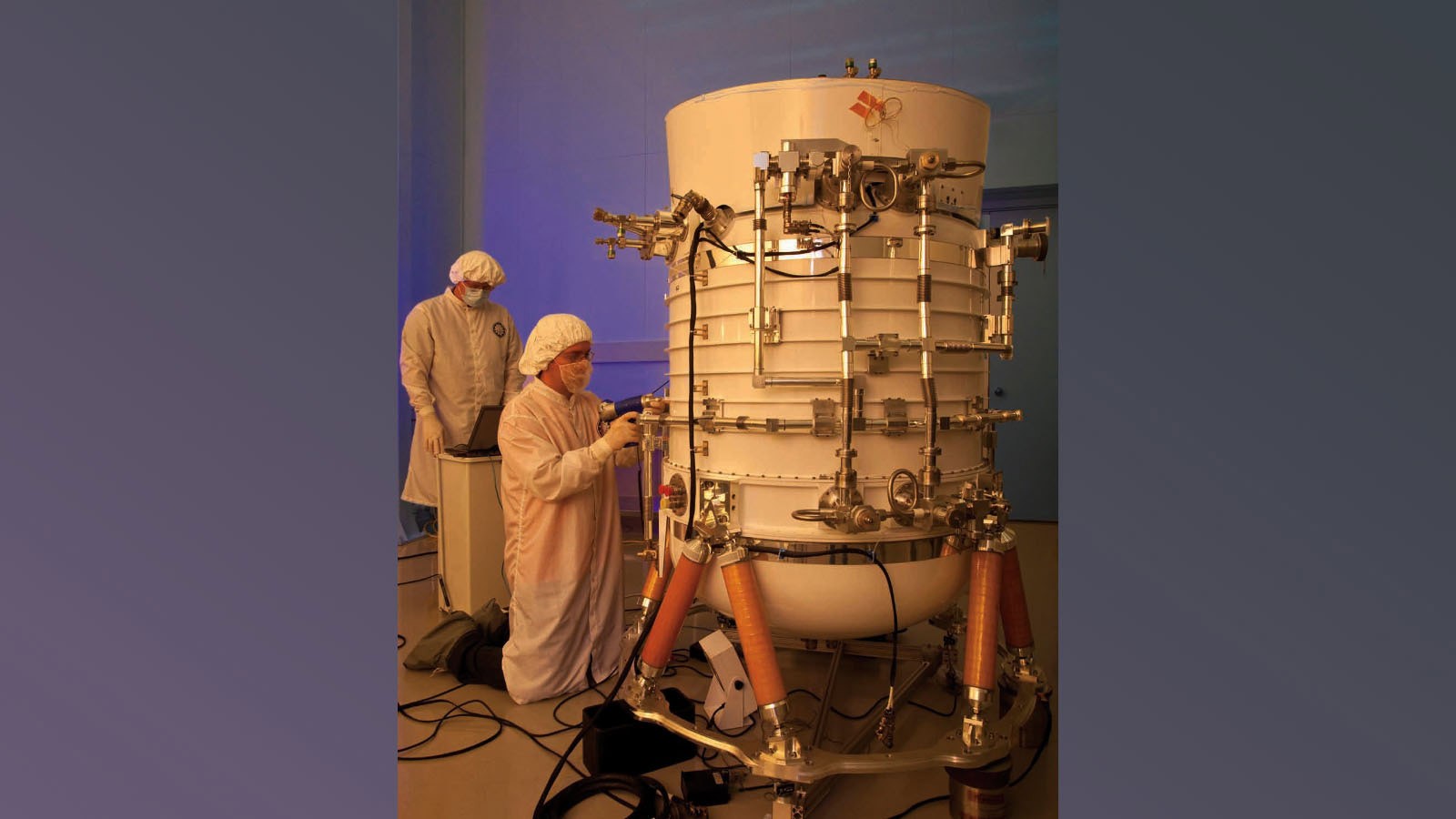 This image shows engineers from the Space Dynamics Laboratory working on the WISE.