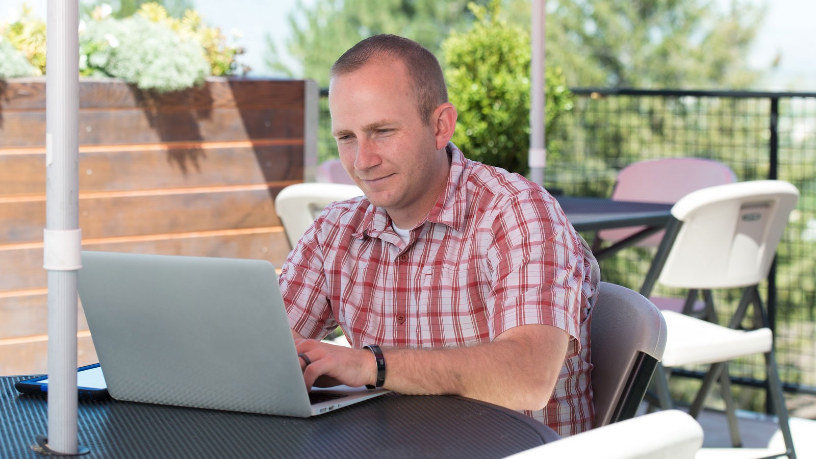 man sitting outside and using his computer.