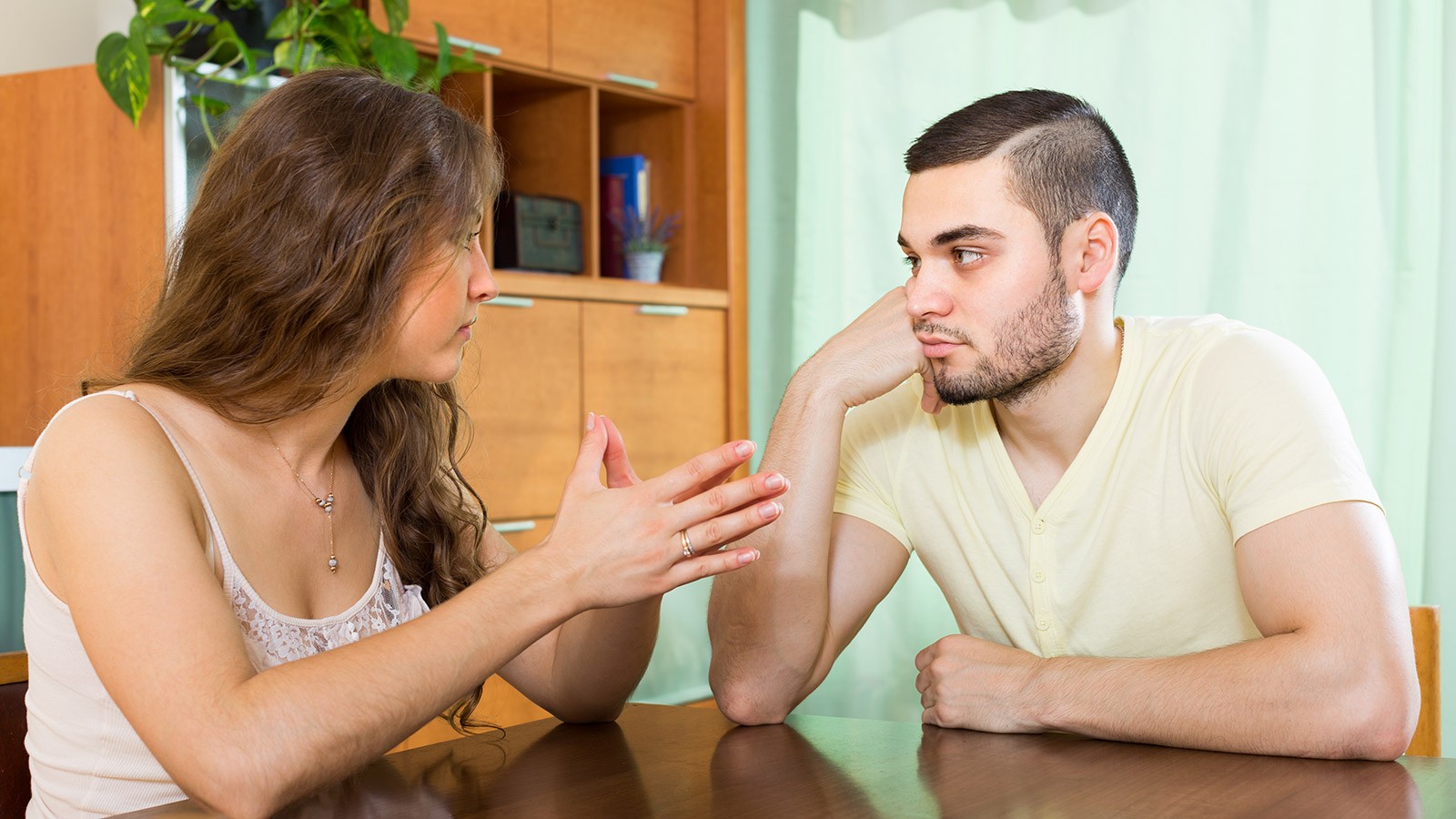 a man and a woman sitting at a table and talking.