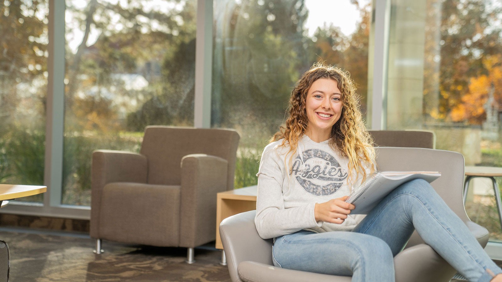 Woman student sitting in a chair on campus.