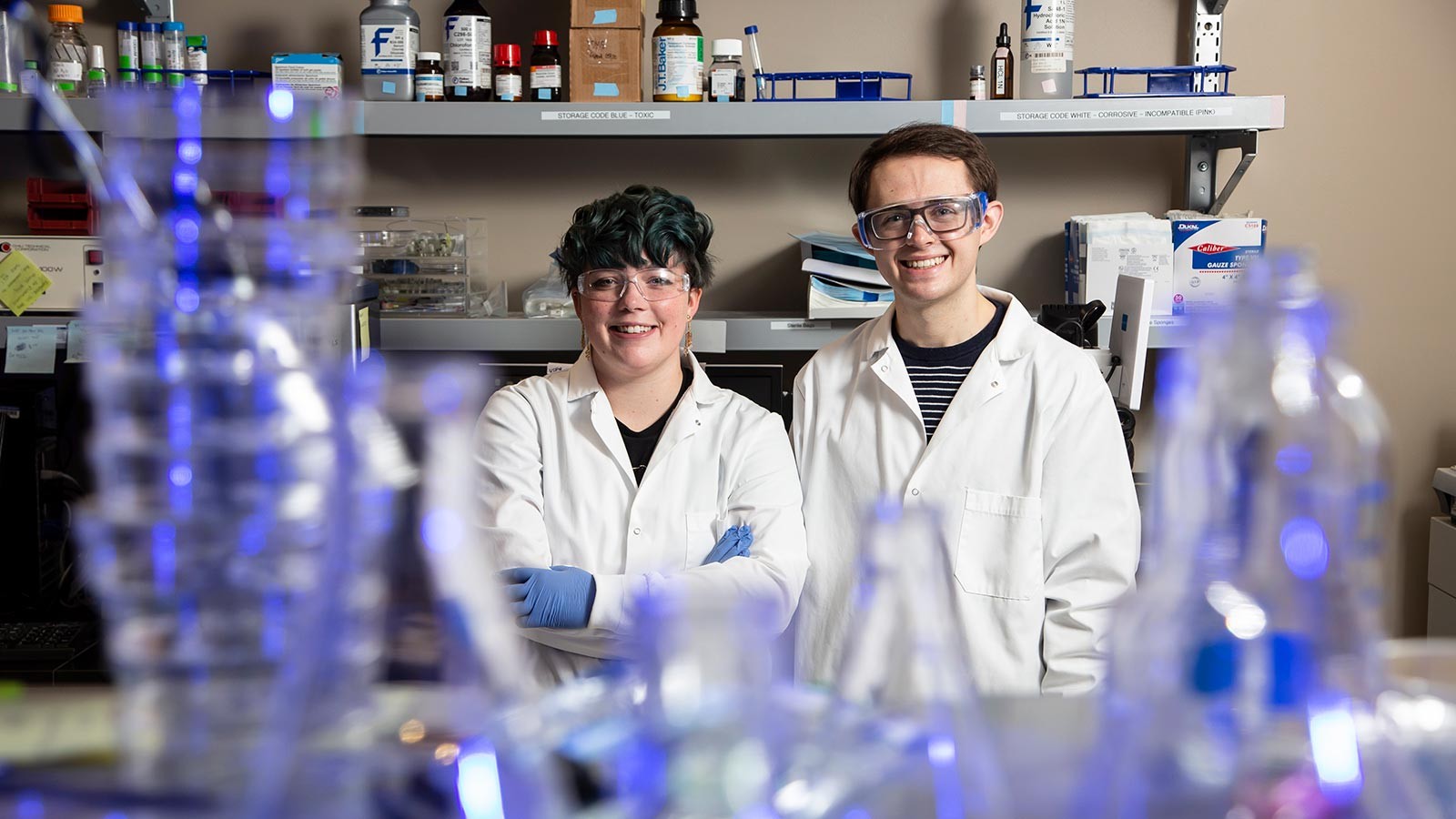 Emilee Rickabaugh and Dillon Weatherston stand among lab equipment.