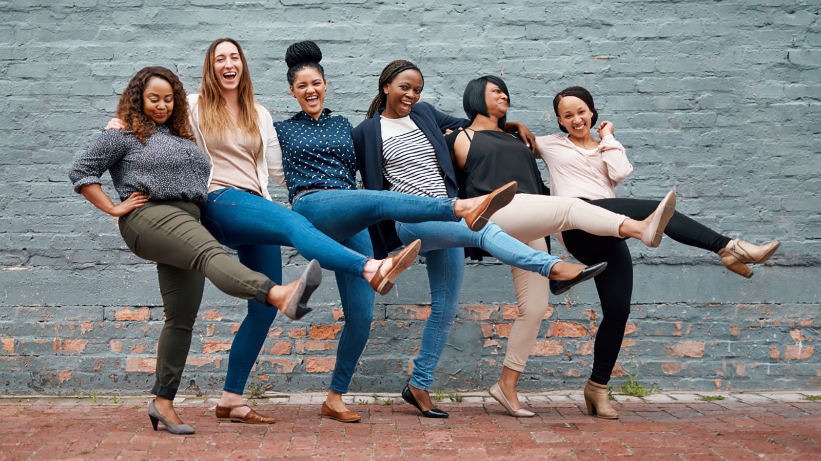 A group of women joining hands.