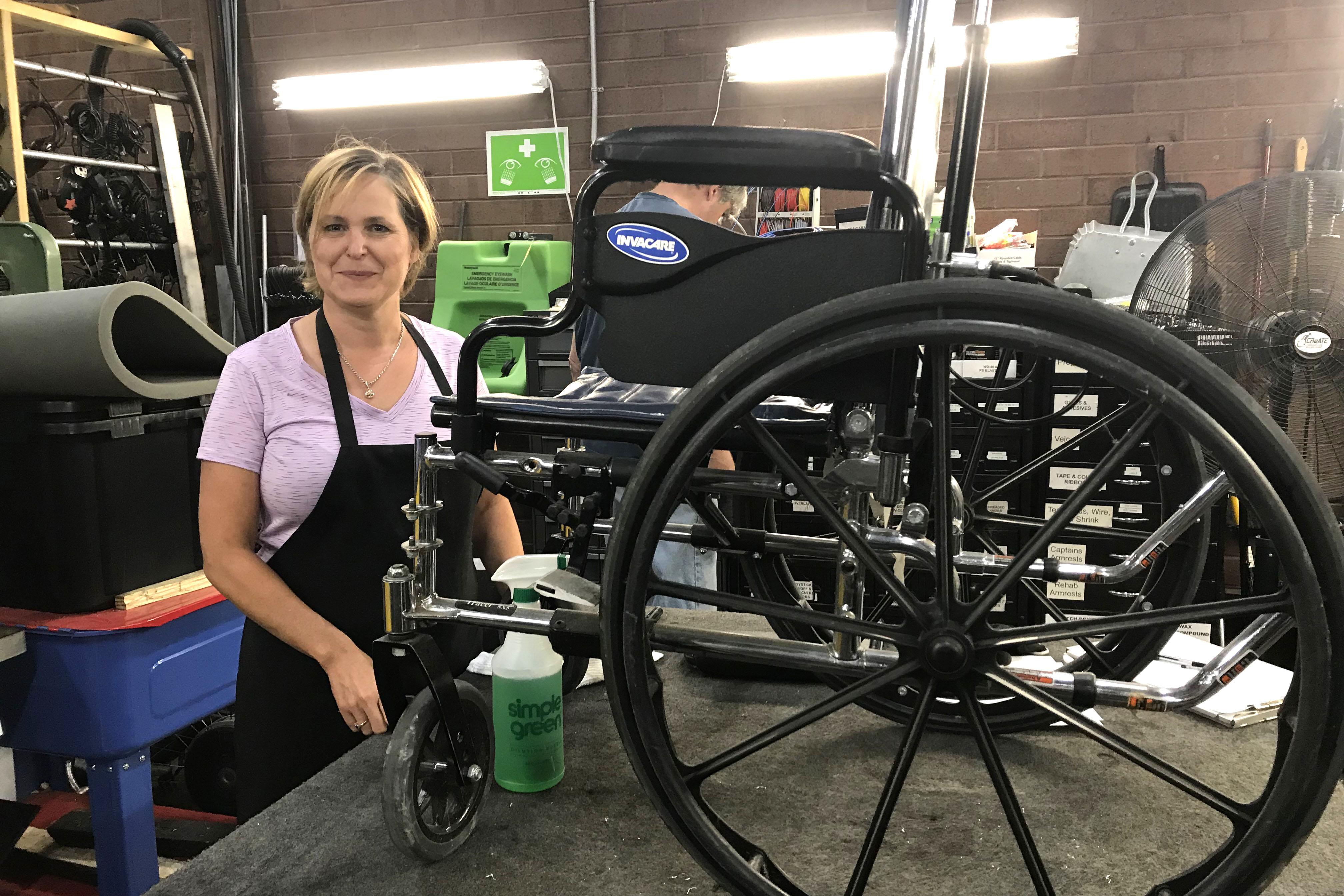 A woman repairs a wheelchair