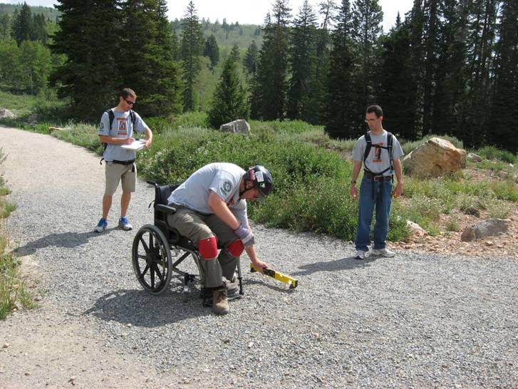 Man in wheelchair working on trail