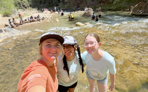 students and advisors next to a river